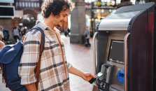 En mann kjøper togbillett og betaler med Morrow Bank kredittkort i mobilen. bilde,