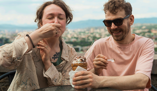 Mann og kvinne spiser is. De er på ferietur og koser seg. bilde.