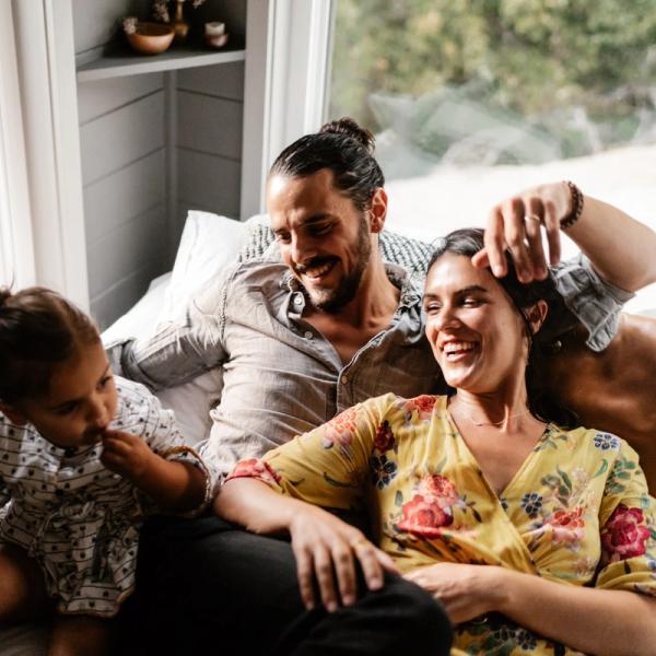 Familj på tre myser i soffan