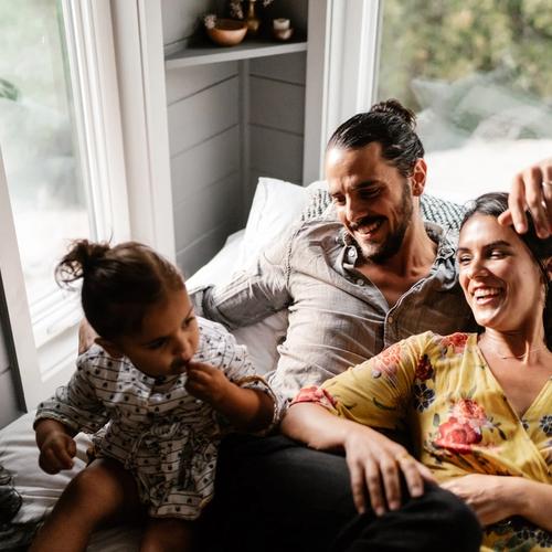 Familj på tre myser i soffan