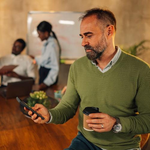 A man sitting with a mobile in his hand. picture.