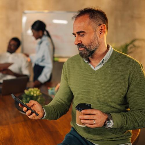 A man sitting with a mobile in his hand. picture.
