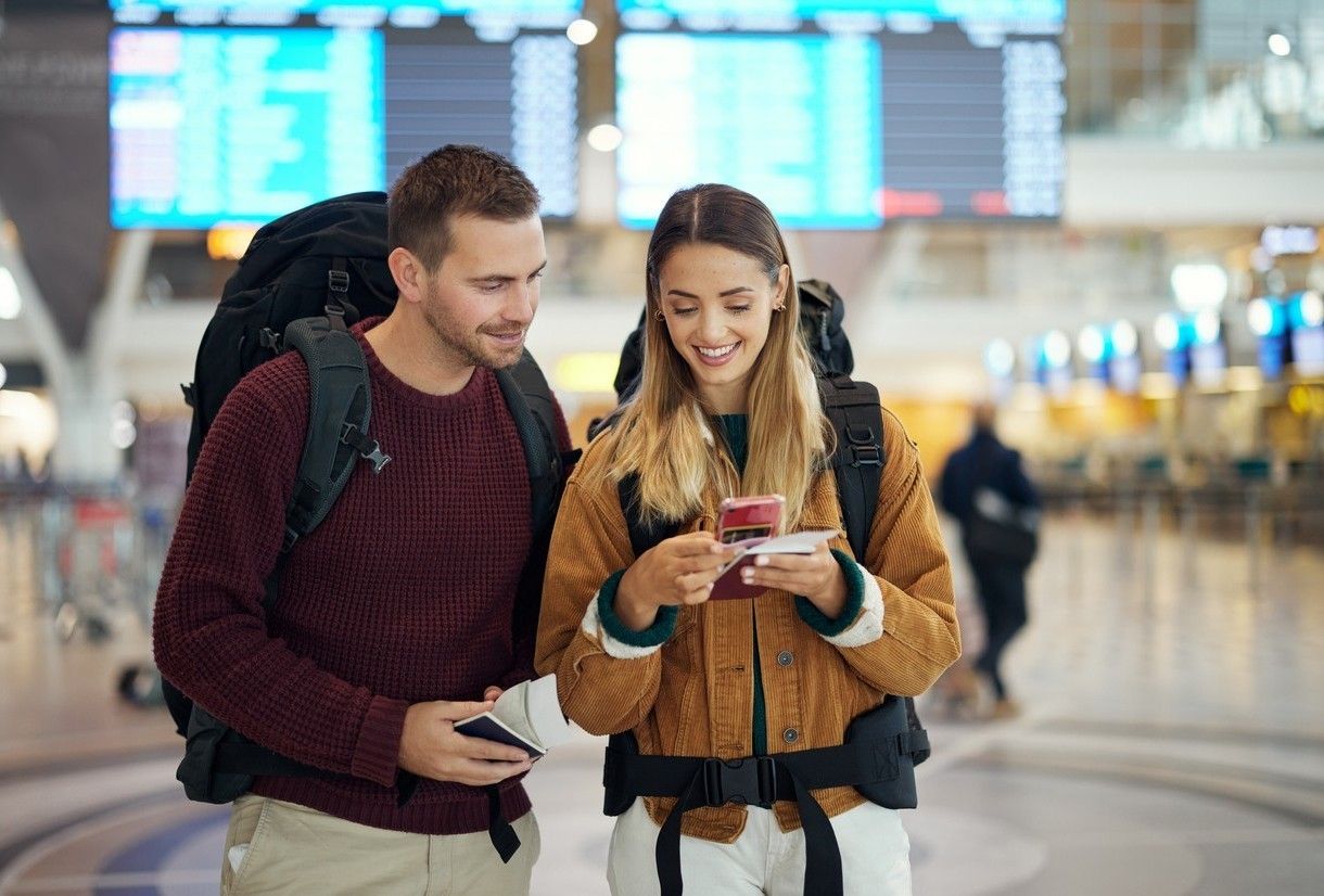 Tjej och kille på flygplatsen ser över biljetter och resedokument. foto.