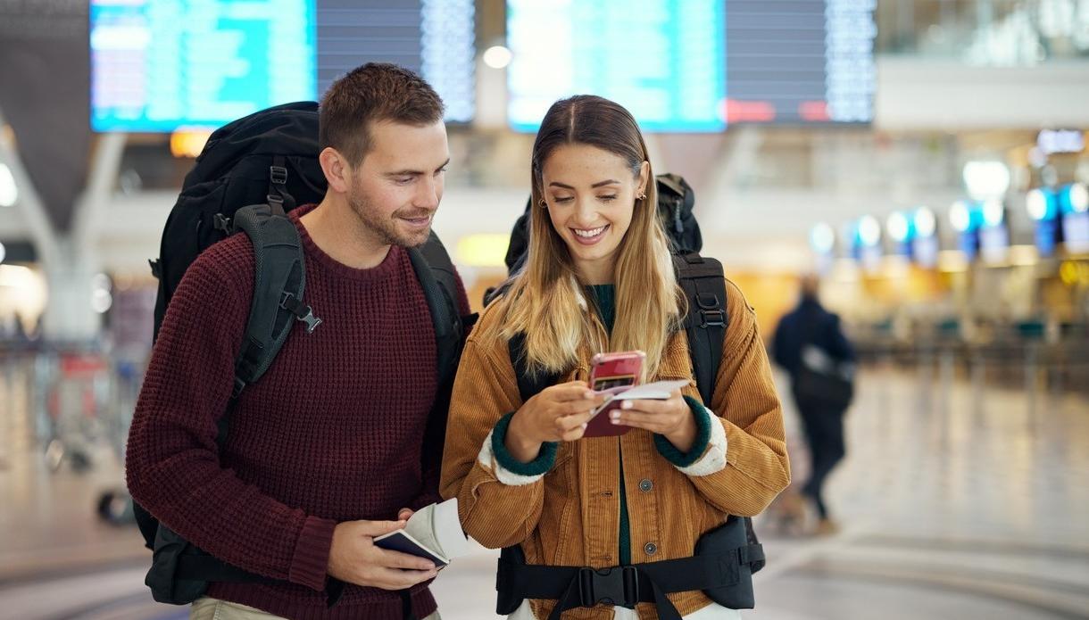 Tjej och kille på flygplatsen ser över biljetter och resedokument. foto.