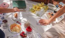 A white picnic blanket filled with colorful berries and biscuits