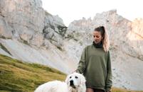 A woman and her dog hiking in the mountains.