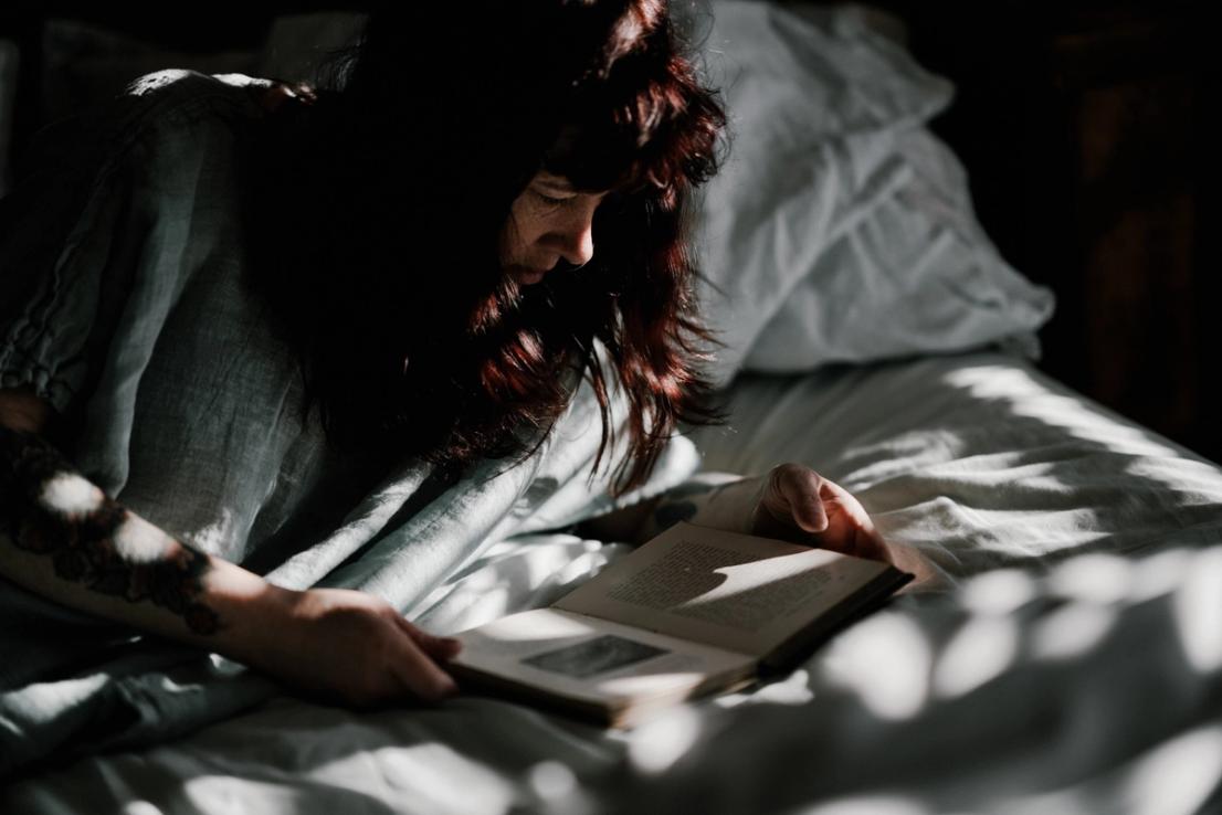 A woman laying in bed reading a book