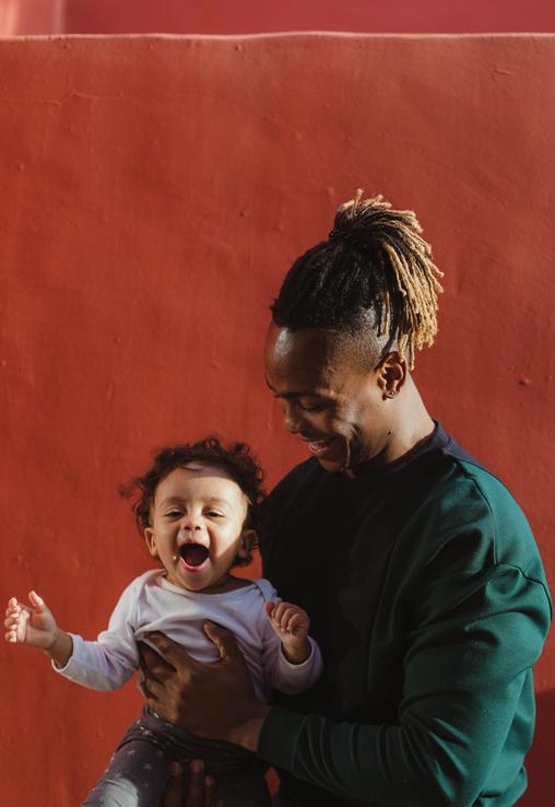A man smiling and holding a child