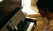 A girl in a white shirt playing piano