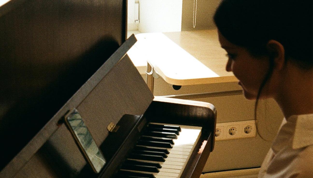 A girl in a white shirt playing piano
