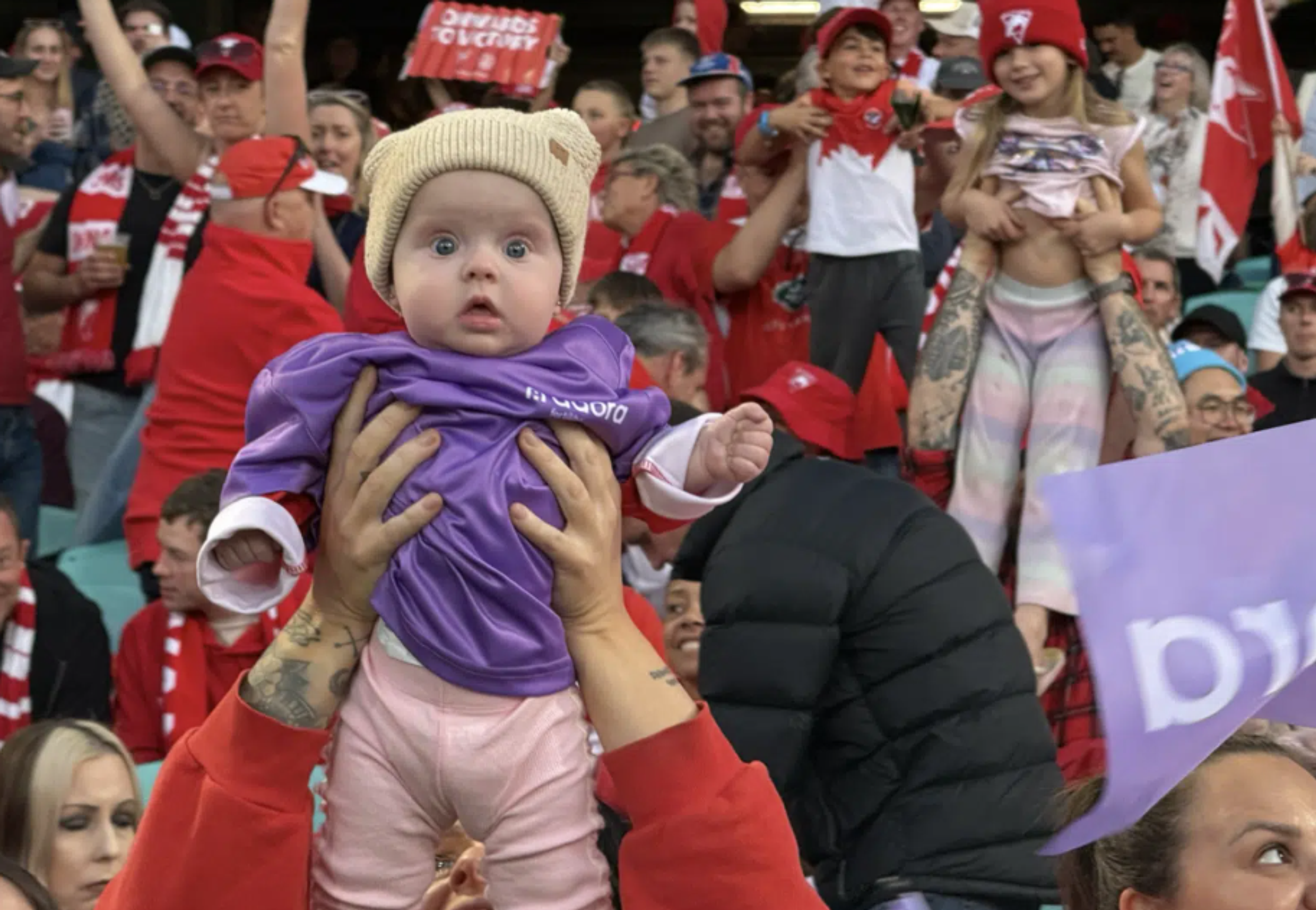 Baby held up Simba style in Adora Fertility activation in partnership with Sydney Swans.