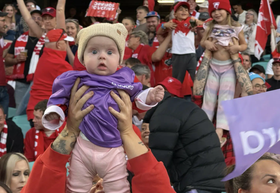 Baby held up Simba style in Adora Fertility activation in partnership with Sydney Swans.
