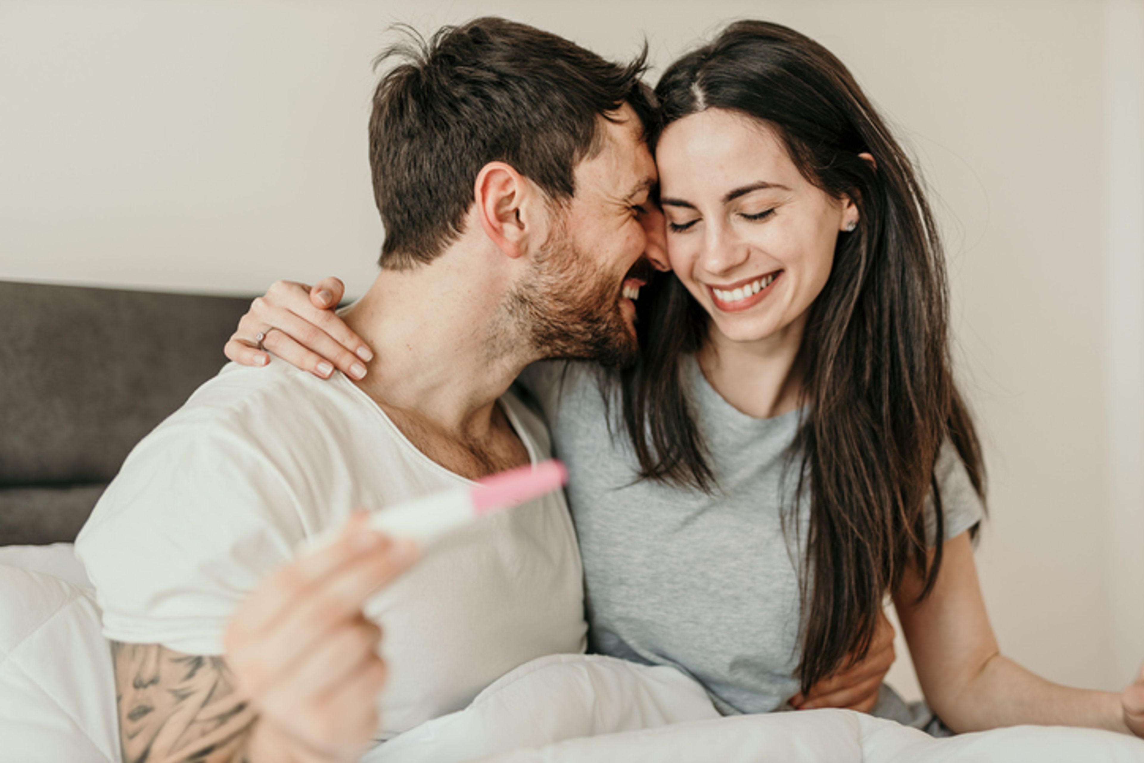 Cropped shot of an affectionate young couple looking excited while looking at a pregnancy test in their bedroom at home