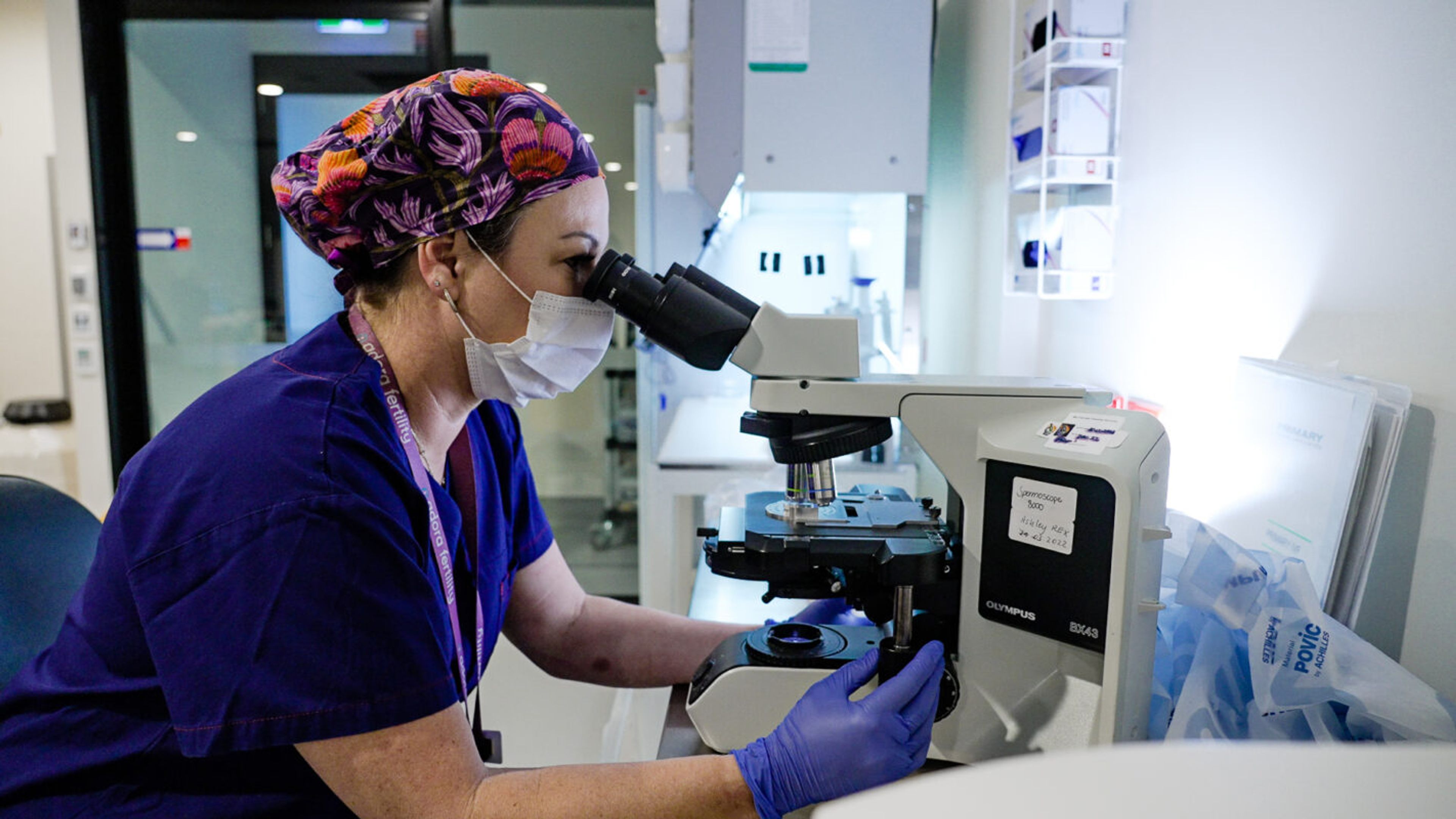 Lab with health care professional using a microscope