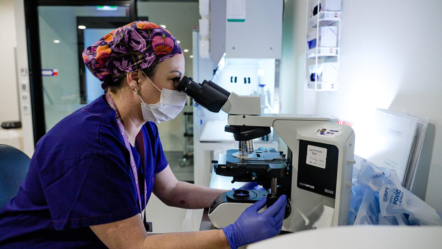 Lab with health care professional using a microscope