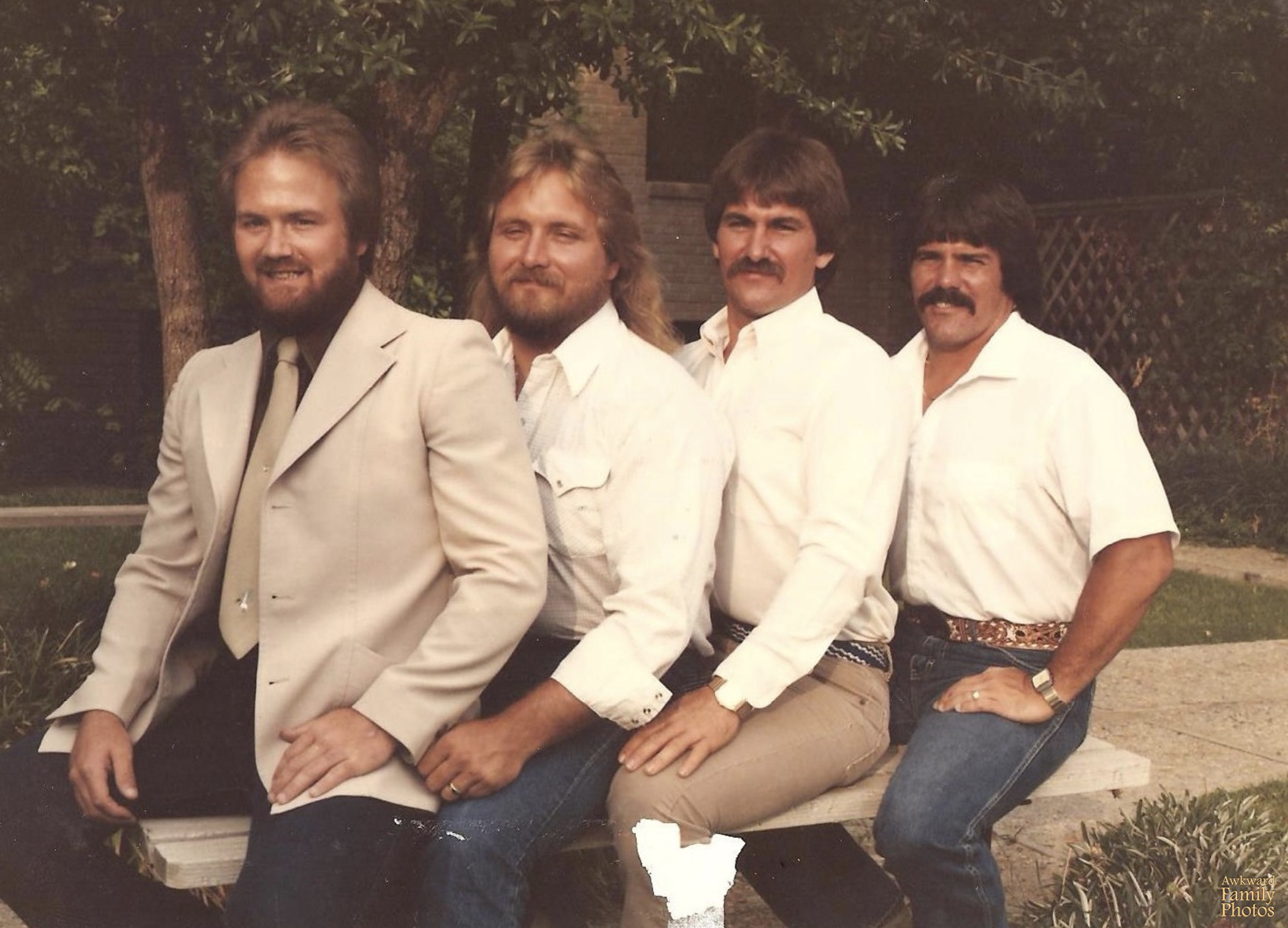 4 men sitting on a bench