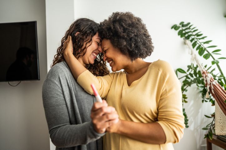 Young beautiful Asian woman in good health wearing a sports uniform is drinking water from a bottle after jogging from the park and running around the village.