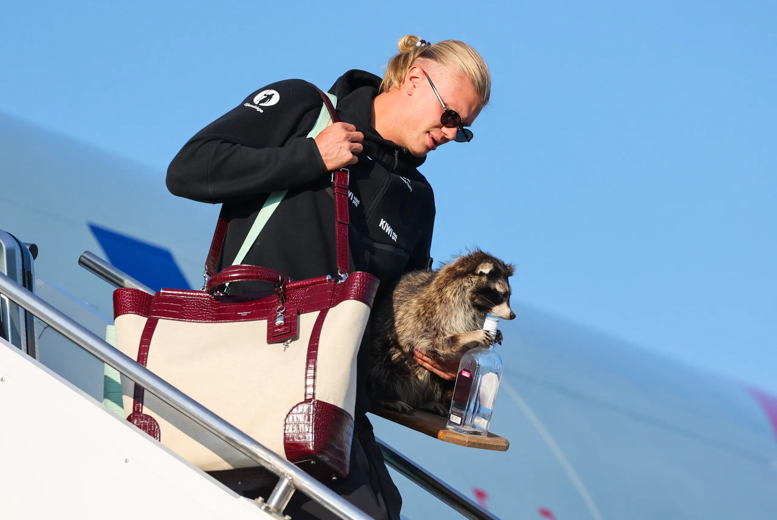 Erling Haaland deplanes with his taxidermy raccoon.  