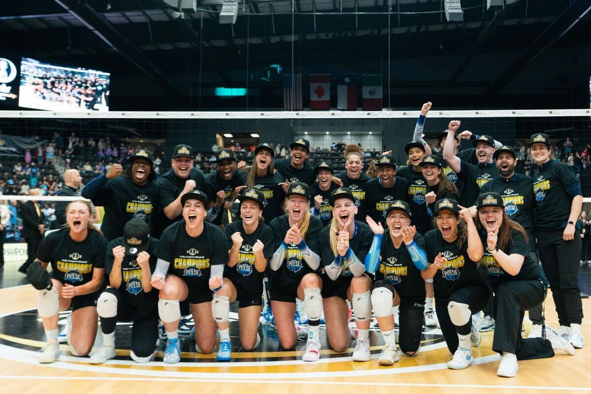 The Dallas Pulse volleyball team pose on the court after a championship win