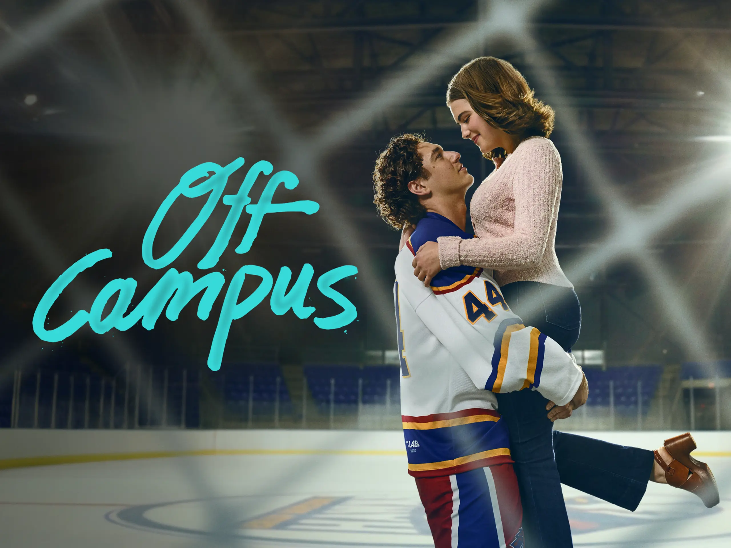 Garrett picks Hannah up off the ground. The show title is shown to the left.