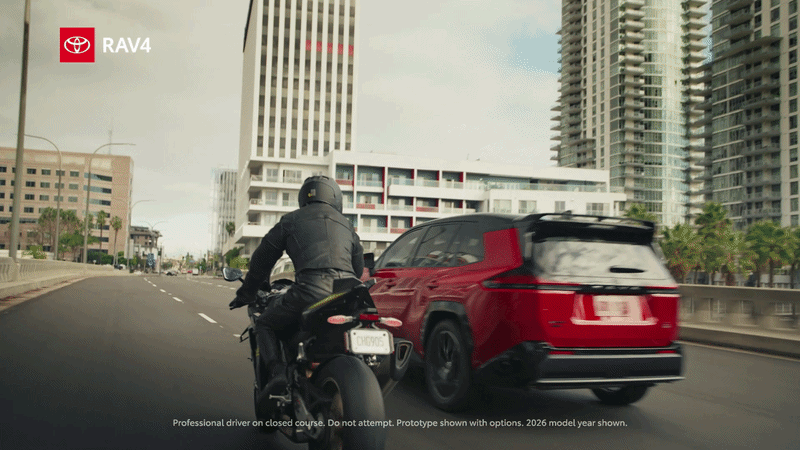 A red RAV4 drives on a bridge trailed by two motorcycles. Text reads "Rapid Acceleration Vehicle 4FUN"