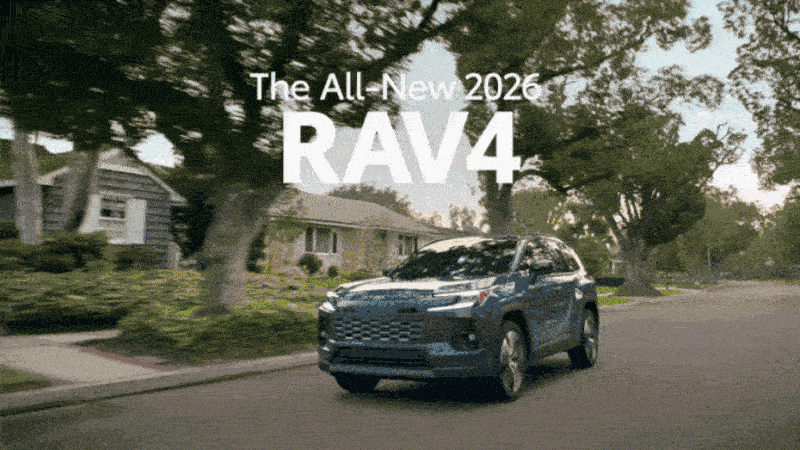 A RAV4 drives down an idyllic residential street.