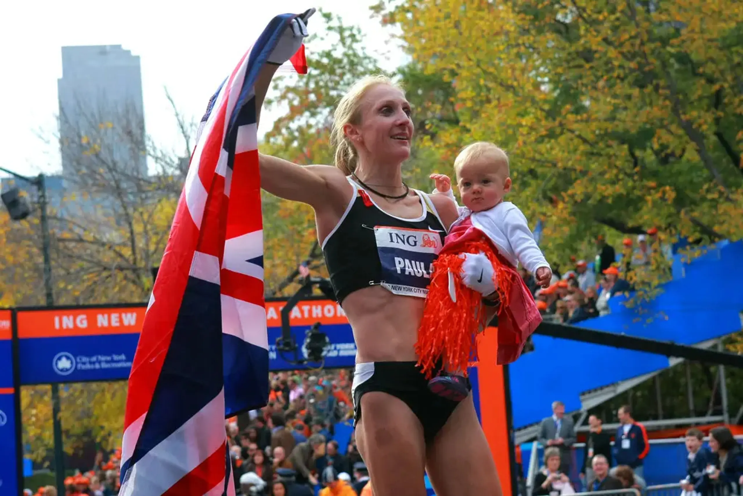 Marathoner Paula Radcliffe waves a British flag while holding her baby after finishing a race.