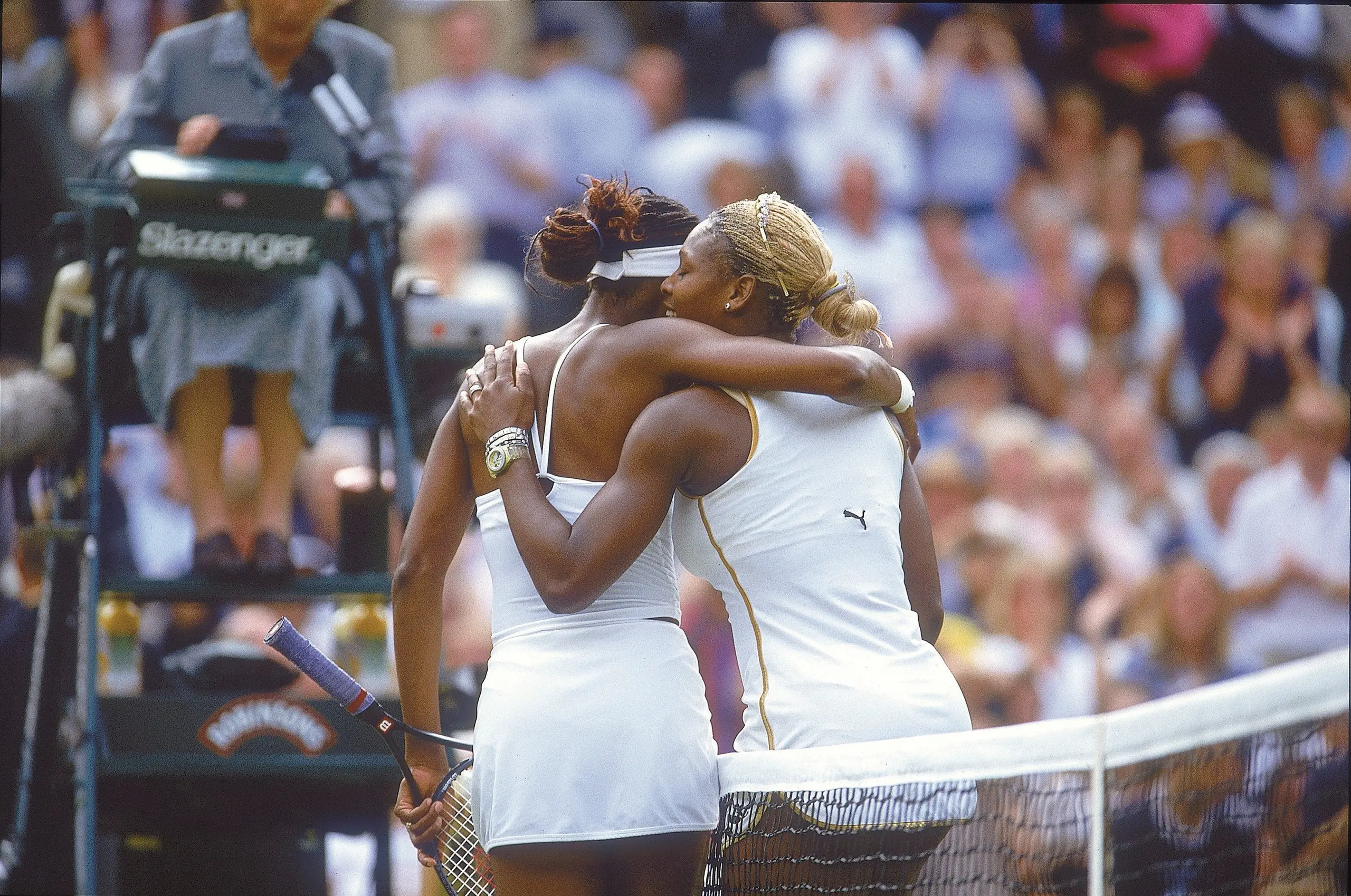 Venus and Serena Williams hug after competing against one another in the 2002 Wimbledon singles Final. 