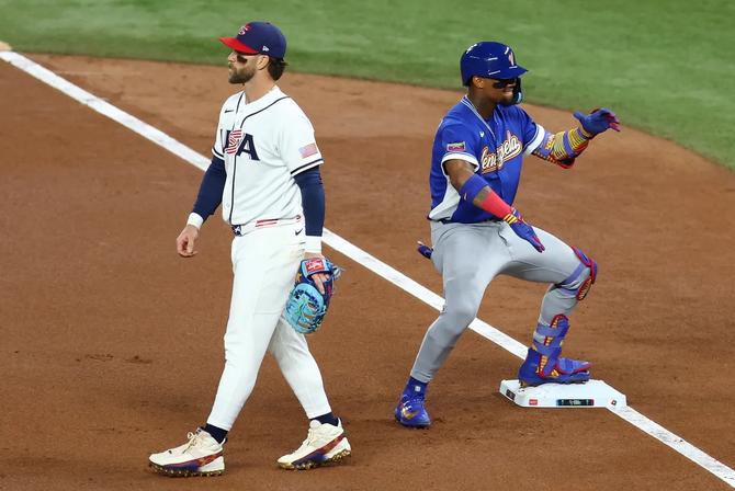 Ronald Acuña Jr. #21 of Team Venezuela reacts after hitting a single in front of Bryce Harper #24 of Team United States during the first inning at loanDepot park on March 17, 2026 in Miami.
