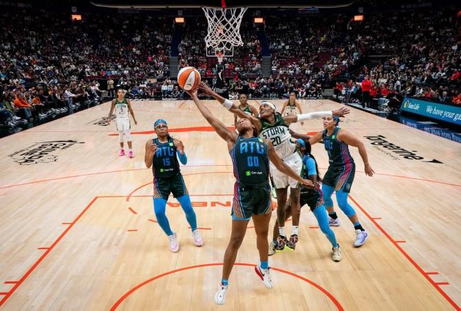 Seattle Storm guard Brittney Sykes attempts to block the shot of the Atlanta Dream’s Naz Hillmon.