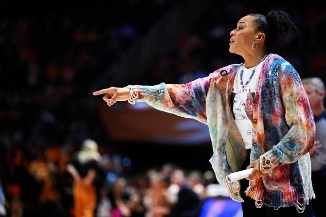 Dawn Staley points while standing on the sideline.