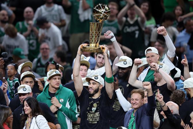 Jayson Tatum lifts the Larry O’Brien Trophy.