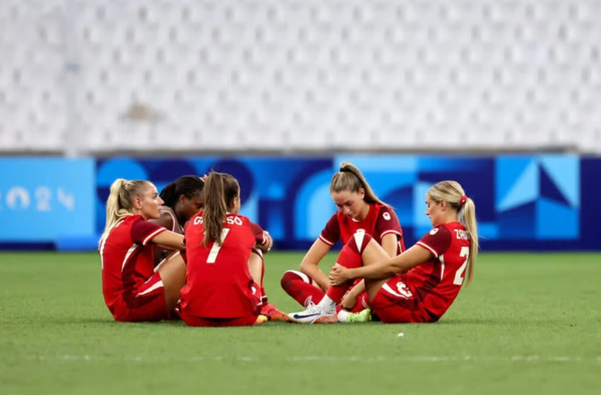 CanWNT players react to their loss after the penalty shootout in the women's quarter-final football match.