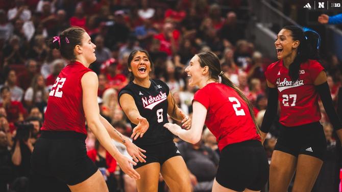 Members of the Nebraska volleyball team celebrate a point.
