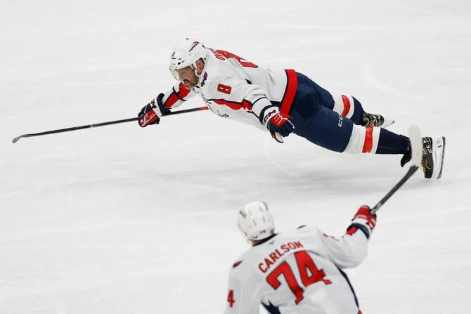 Alex Ovechkin dives on the ice after breaking the NHL all-time scoring record.