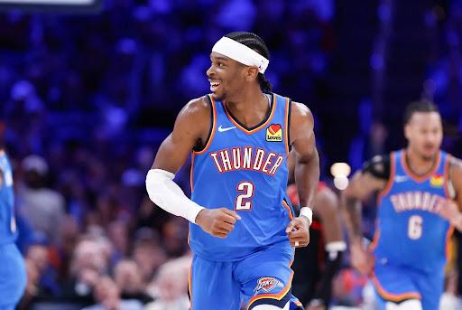 Oklahoma City Thunder superstar Shai Gilgeous-Alexander smiles as he runs down the court.