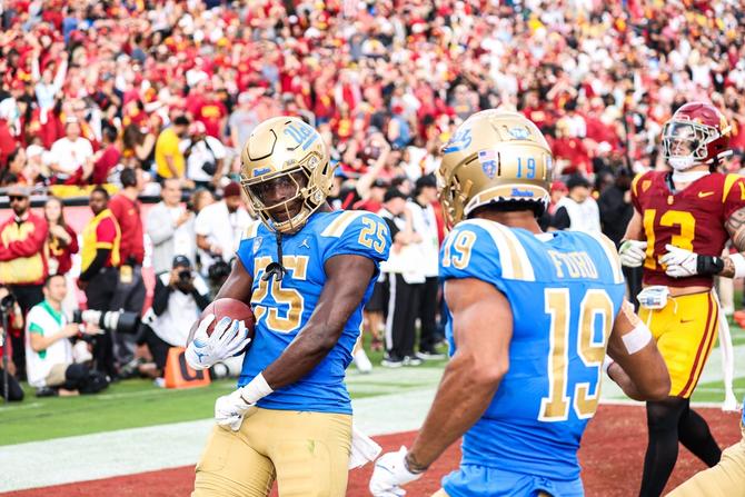 Two UCLA football players celebrate a touchdown during their November 18th game against USC.