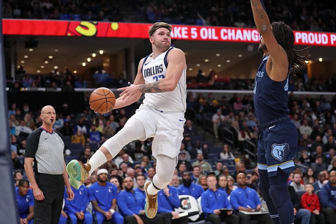 Luka Doncic #77 of the Dallas Mavericks looks to pass against Derrick Rose #23 of the Memphis Grizzlies