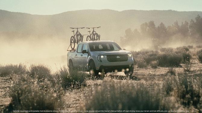 A Ford Maverick truck driving on a gravel road