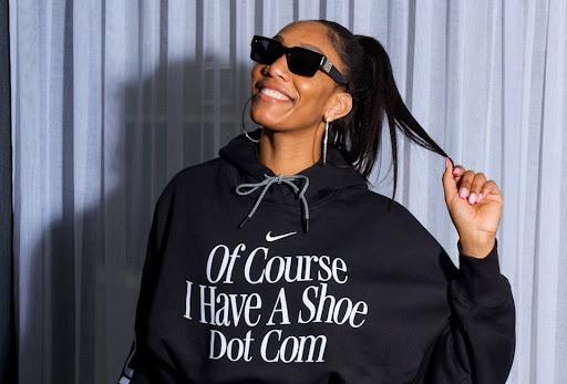 WNBA superstar A’ja Wilson poses in a sweatshirt that says “Of course I have a shoe dot com.”