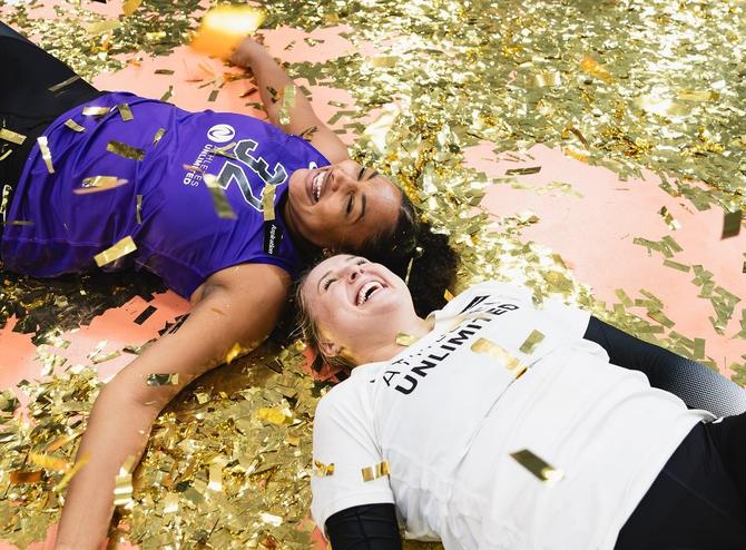 Outside hitter Nia Parker-Robinson and libero Kendall White lie in confetti following the conclusion of the 2023 AU Pro Volleyball season.