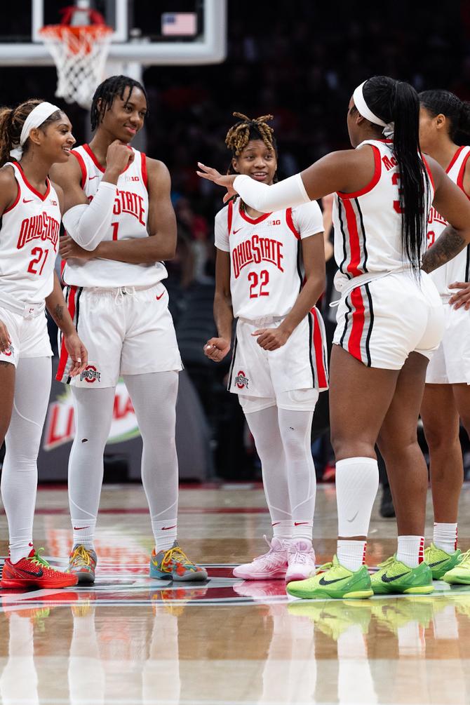 The Ohio State women’s basketball team, pictured chatting during a game, is one of five undefeated women’s basketball teams.