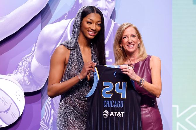 LSU women’s basketball star–turned–Chicago Sky draftee Angel Reese poses with WNBA commissioner Cathy Engelbert while holding a No. 24 Chicago Sky jersey.