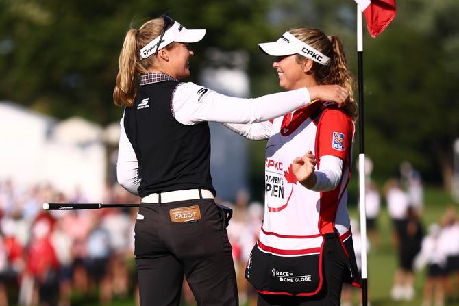 Brooke M. Henderson of Canada and her caddie and sister Brittany Henderson embrace on the 18th green after Brooke won the CPKC Women's Open 2025 at Mississaugua Golf and Country Club