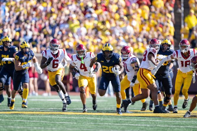 Michigan football running back Kalel Mullings pulls away from the USC defense.