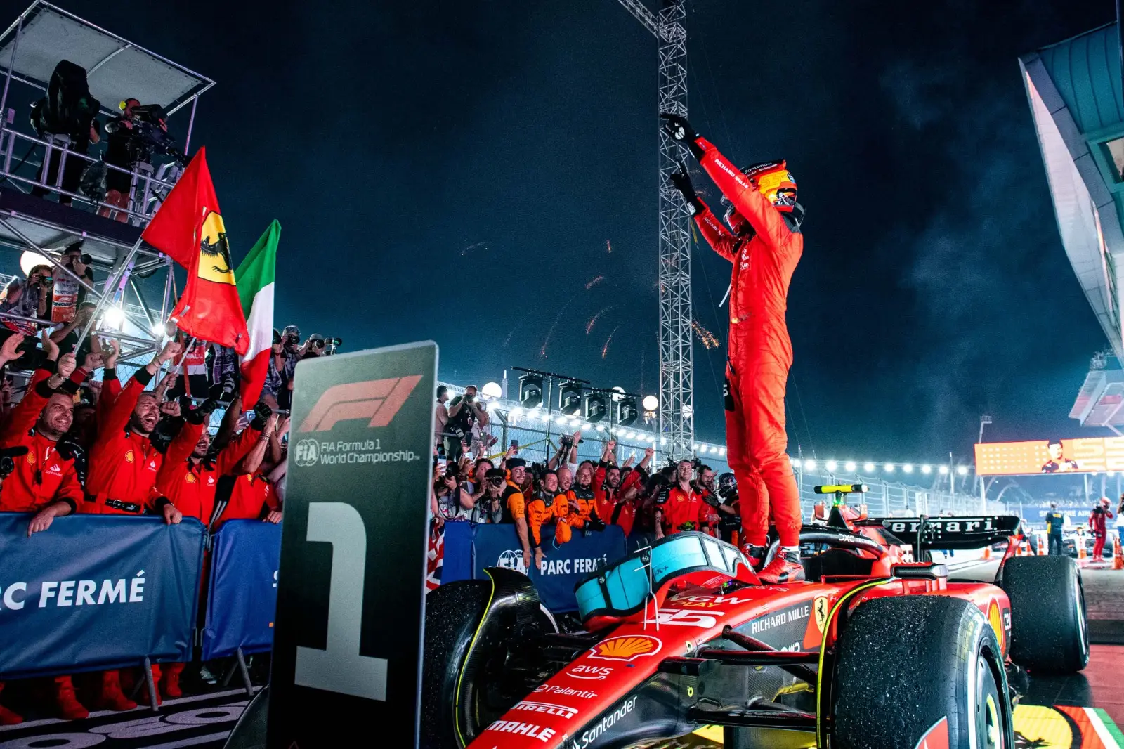 Ferrari driver Carlos Sainz standing on top of his car after winning the 2023 Singapore Grand Prix. 