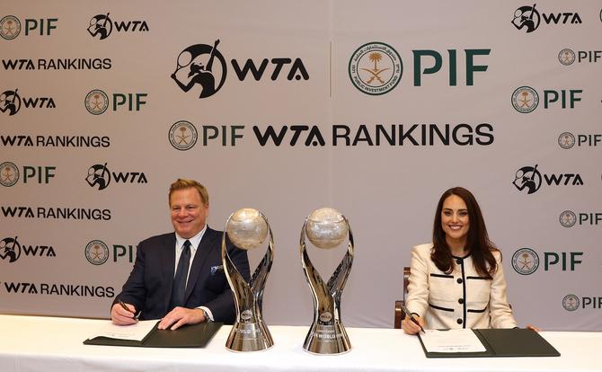 Kevin Foster, Head of Corporate Affairs, PIF and Marina Storti, WTA Ventures CEO, sit at a table, pens in hand, to sign the partnership agreement between the two entities.