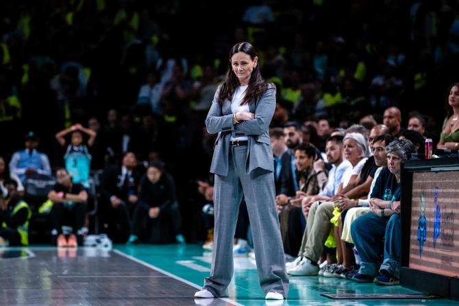 Sandy Brondello stands on the sidelines with her arms crossed during a game.