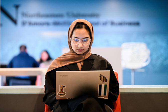 A student typing on her laptop