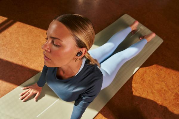 A woman stretching while wearing Powerbeats Fit